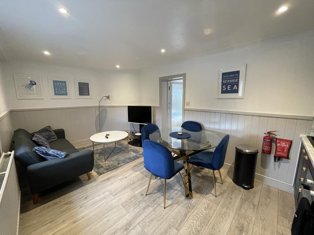 Lot: 62 - DETACHED SEAFRONT PROPERTY FULLY REFURBISHED AND ARRANGED AS THREE UNITS - Living room/kitchen with panelled walls
